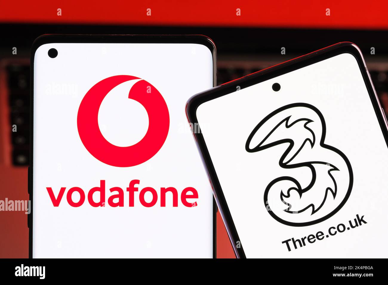 Vodafone und drei mögliche Fusionkonzepte. Die Smartphones werden zusammen mit den Logos der britischen Mobilfunkanbieter auf den Bildschirmen angezeigt. Stafford, Großbritannien, Oc Stockfoto