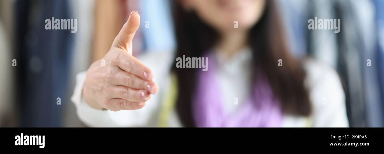 Frau Näherin hält die Hand zum Händeschütteln aus der Nähe Stockfoto