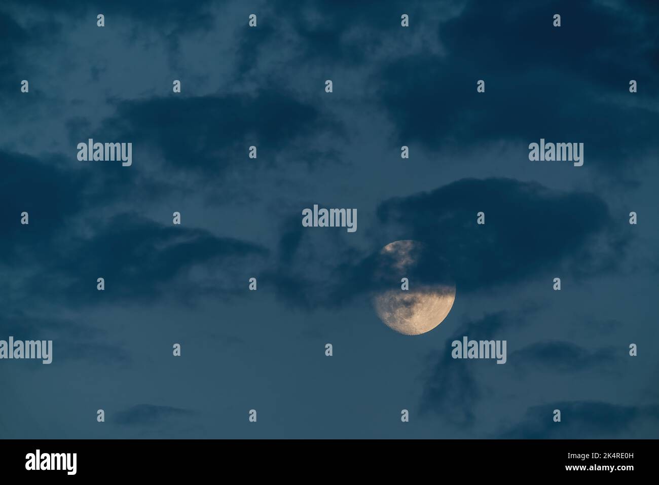 Wachsender Mond in Wolken am Abendhimmel Stockfoto
