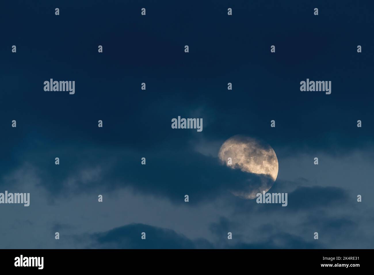 Wachsender Mond in Wolken am Abendhimmel Stockfoto
