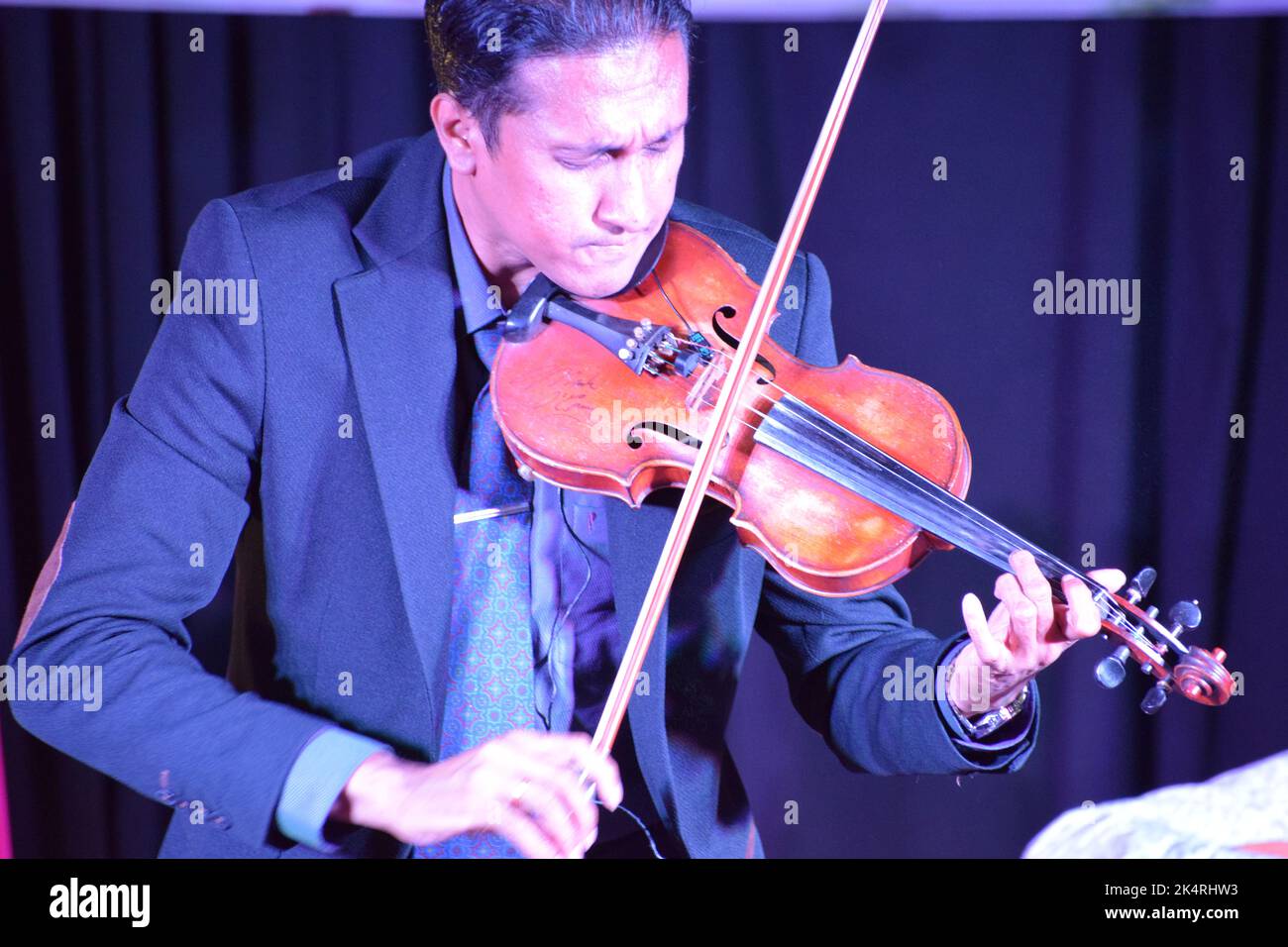 Mann, der Geige spielt und Emotionen und Ausdrücke zeigt Stockfoto