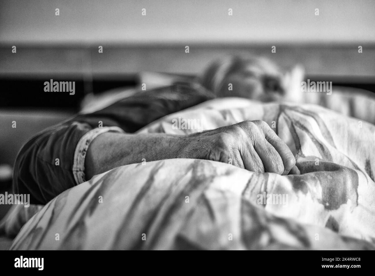 Faltige Hand einer alten Frau, die im Bett lag. Leitender Patient Stockfoto