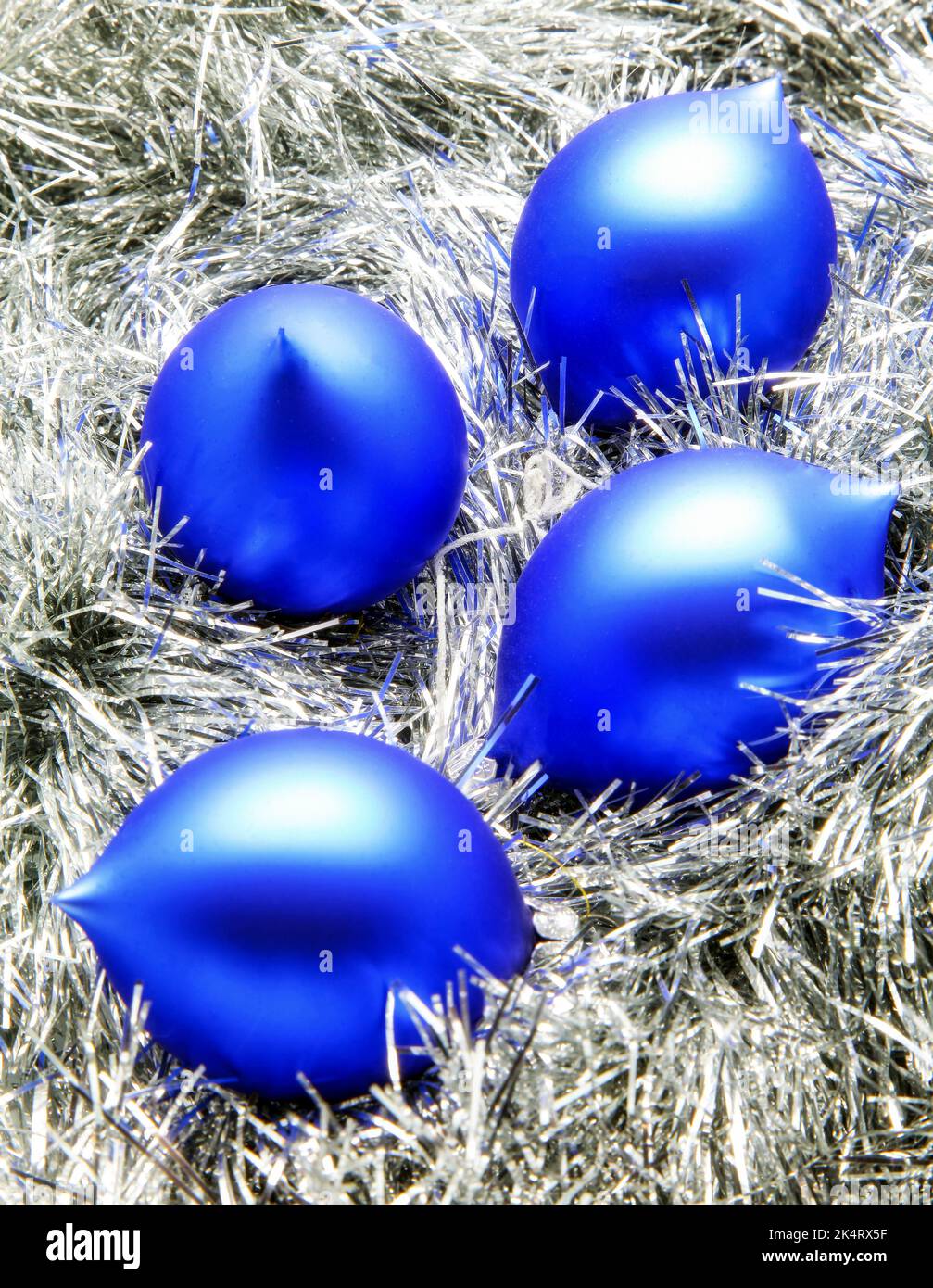 Blaue weihnachtskugeln auf silberner Dekoration. Stockfoto