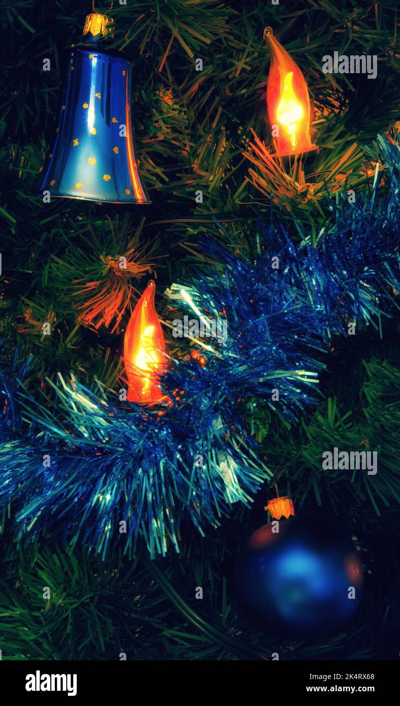Weihnachtslicht glänzte auf geschmücktem weihnachtsbaum mit blauer Kugel und Glocke. Stockfoto