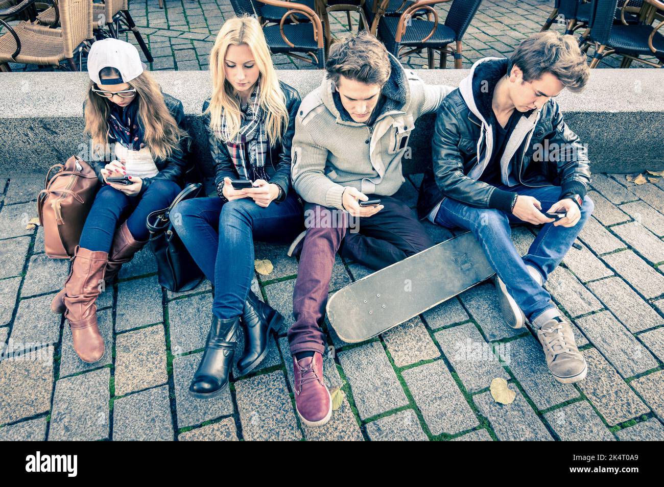 Gruppe Junger hipster Freunde spielen mit Smartphone mit gegenseitigen Desinteresse an den jeweils anderen - Moderne situation der Technologie Interaktion in Alie Stockfoto