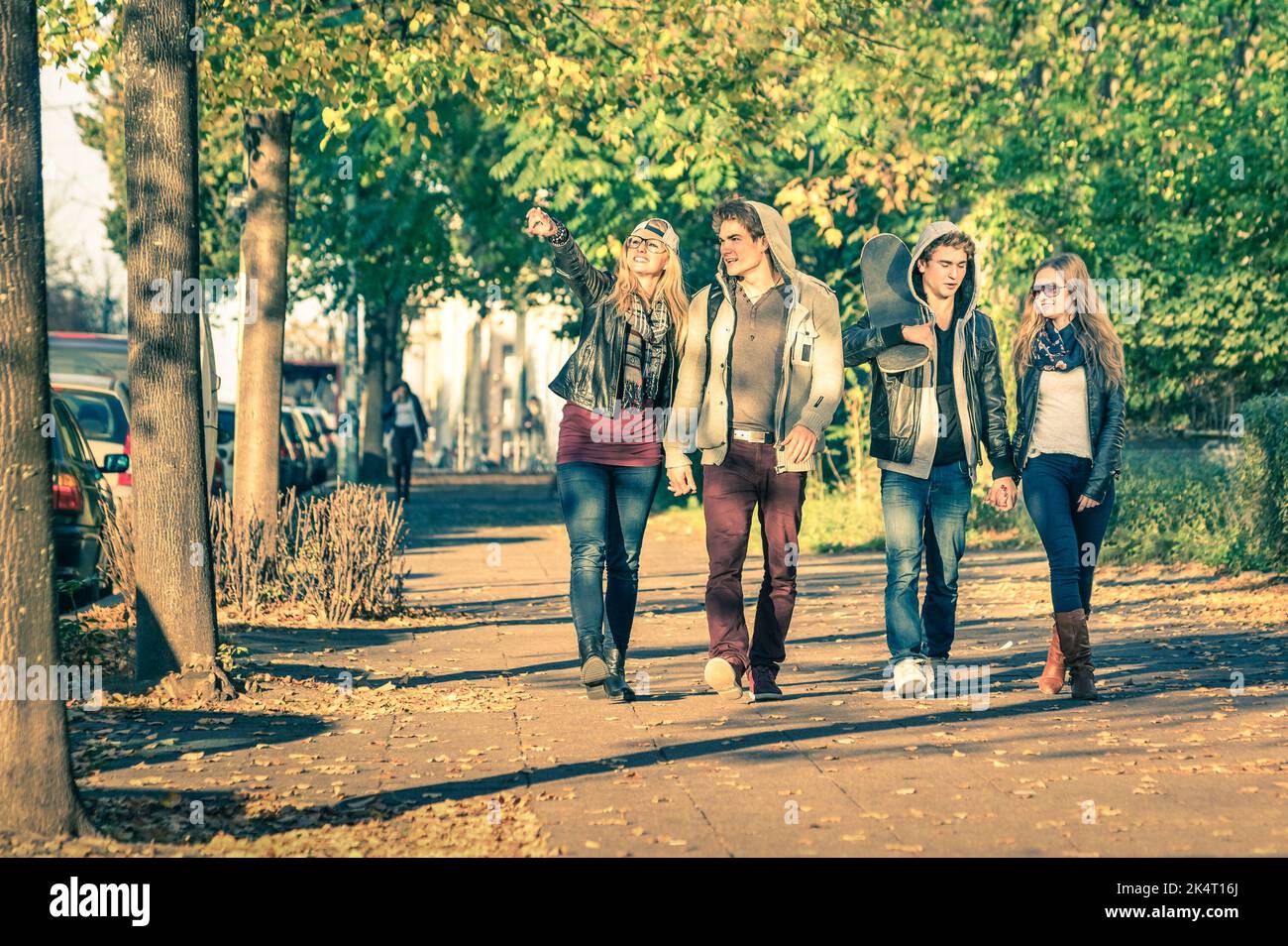 Gruppe von glücklichen besten Freunden mit alternativen Mode Blick zu Fuß im Park - Hipster Touristen Spaß im Freien an sonnigen Wintertag - Universität Stockfoto