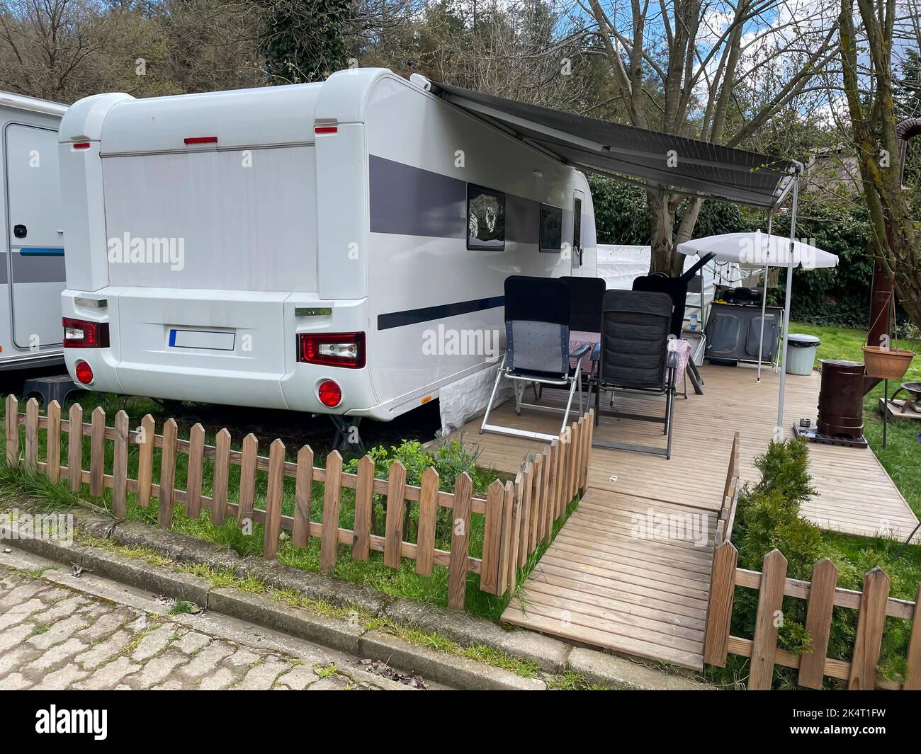 Wohnmobil-Wohnwagen mit Markise auf der Veranda auf einem Wohnmobil-Campingplatz. Caravan Camping Konzept. Istanbul, Türkei - 04. April 2022. Stockfoto