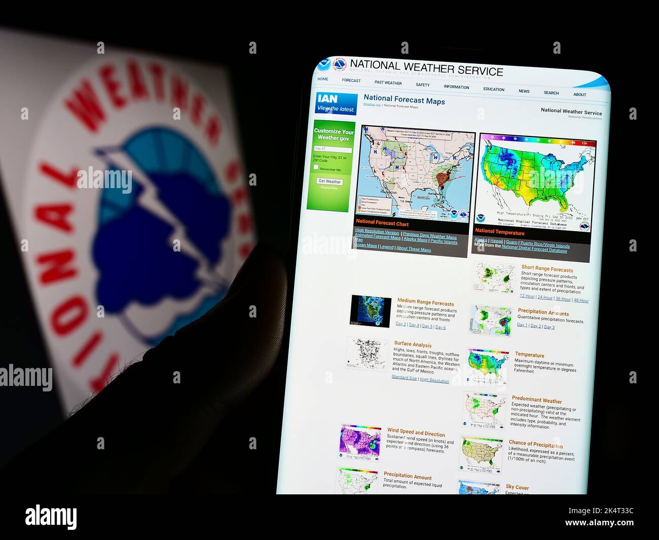 Person, die Mobiltelefon mit der Webseite der US-Agentur National Weather Service (NWS) auf dem Bildschirm vor dem Logo hält. Konzentrieren Sie sich auf die Mitte des Telefondisplays. Stockfoto