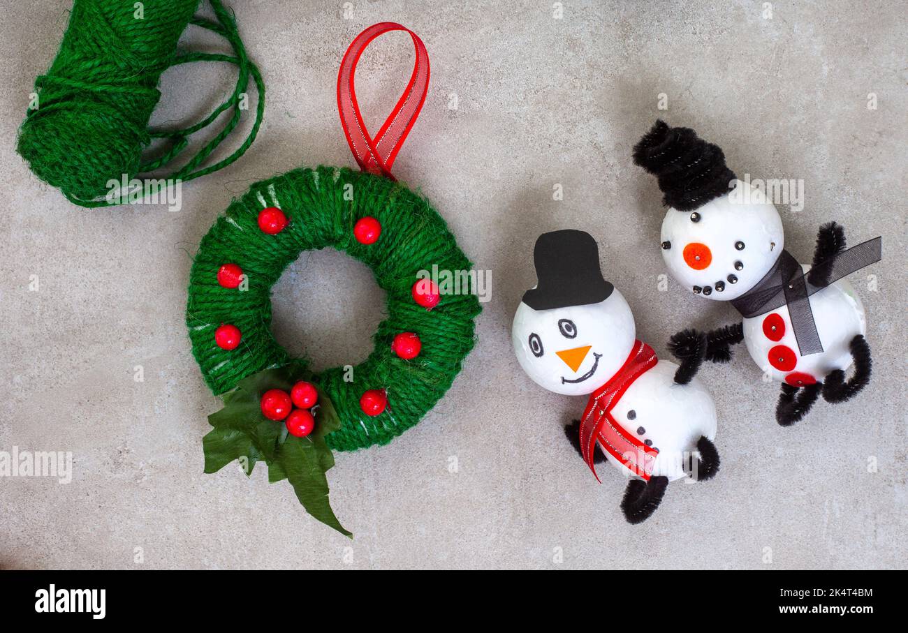Kinder Weihnachtsbasteln von Schneemann und Kranz Ornamente mit Polystyrol, Schnur, Pfeifenreiniger und mehr. Stockfoto