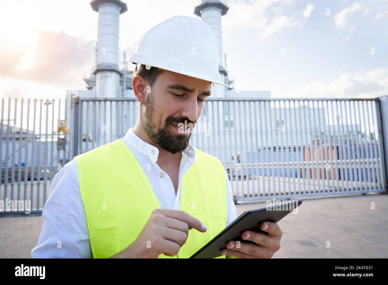 Nahaufnahme eines kaukasischen Ingenieurs, der bei einer Inspektion in einem thermoelektrischen Werk ein digitales Tablet verwendet. Arbeiter außerhalb des Kraftwerks. Stockfoto