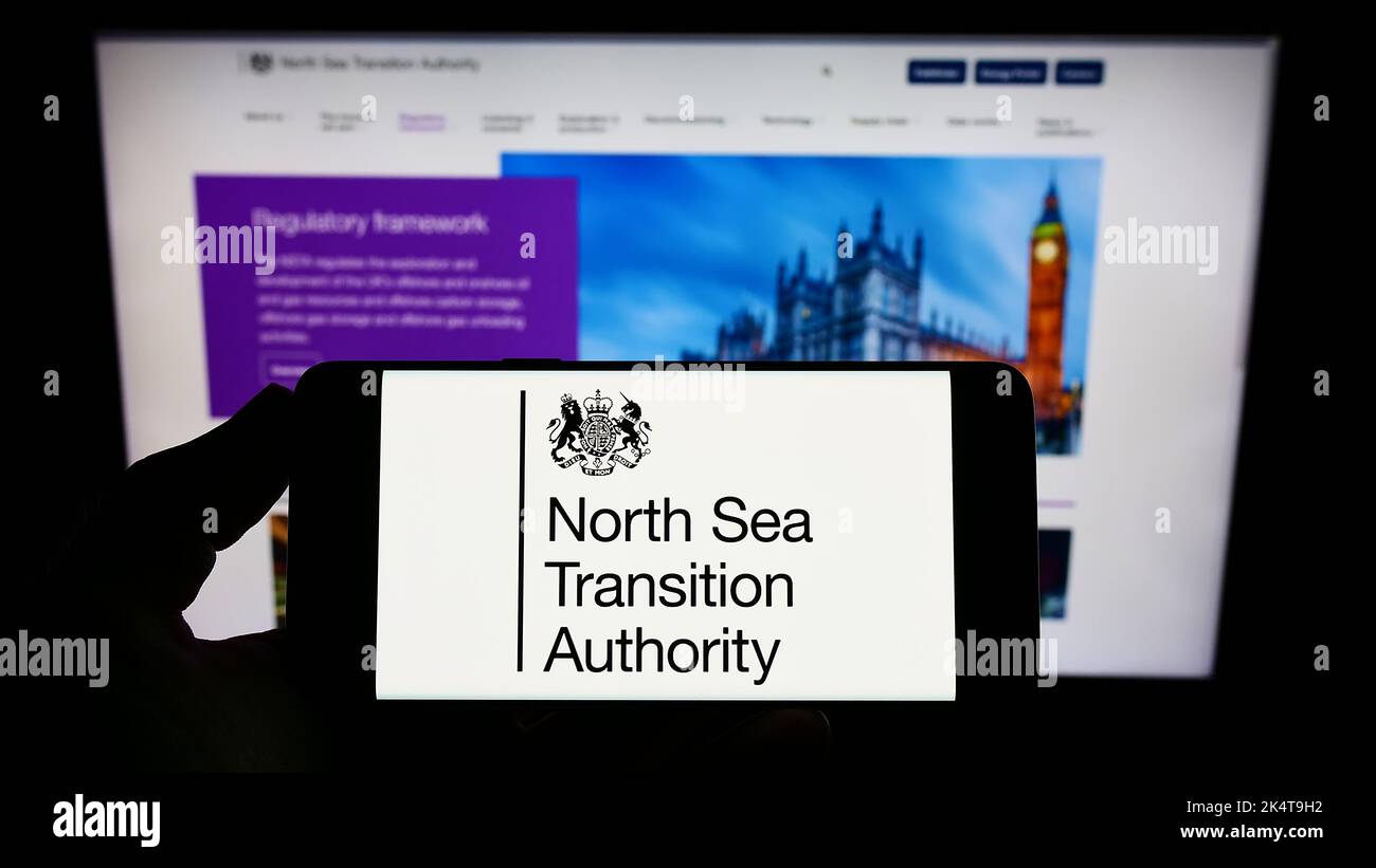 Person, die das Smartphone mit dem Logo der britischen North Sea Transition Authority (NSTA) auf dem Bildschirm vor der Website hält. Konzentrieren Sie sich auf die Telefonanzeige. Stockfoto