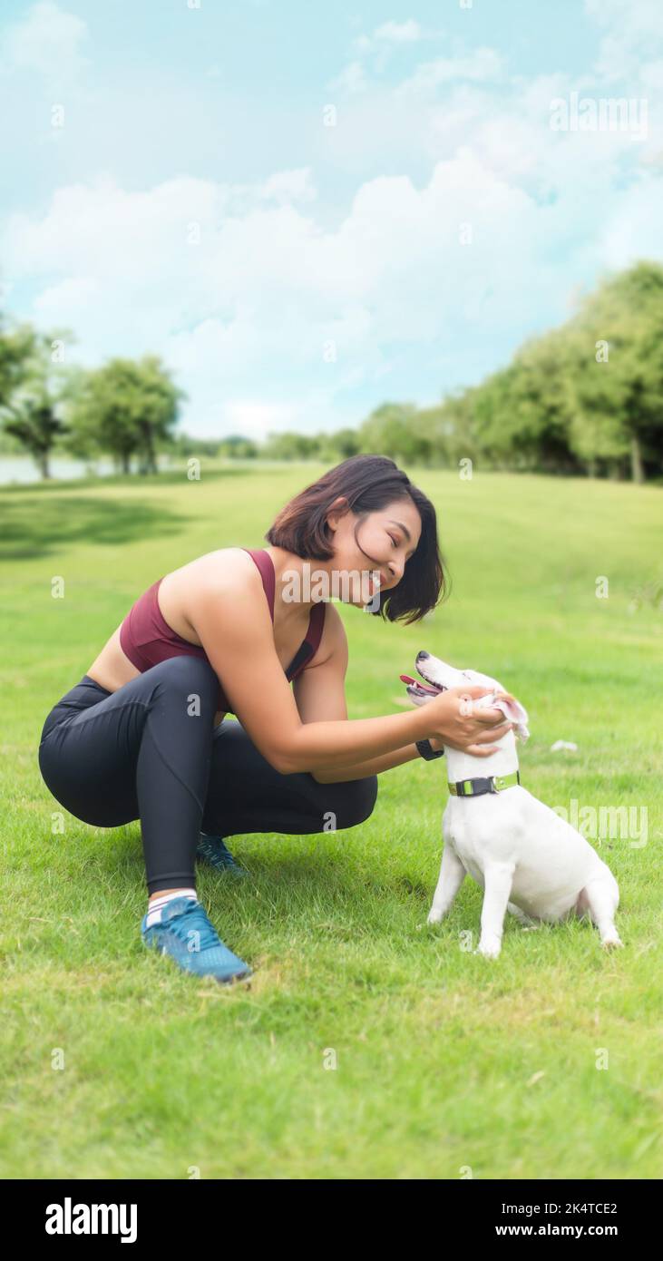 Happy Moment Frau und Hund auf Outdoor-Park. Gute Beziehung zu Mensch und Tier an sonnigen Tagen Stockfoto