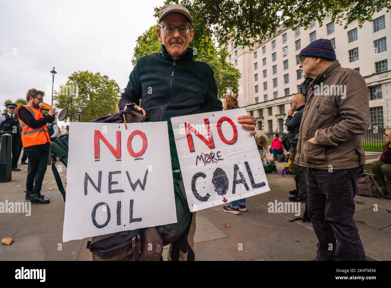 London, Großbritannien. 4 Oktober 2022 . Ein Protestler hält die Zeichen No New Oil und No More Coal, während Klimaaktivisten von Just Stop Oil ihren Protest gegenüber der Downing Street fortsetzen, um die britische Regierung zu fordern, alle zukünftigen Lizenzen für die Exploration, Entwicklung und Produktion von Öl und Gas im Vereinigten Königreich sofort einzustellen Kredit: amer Ghazzal/Alamy Live News. Stockfoto