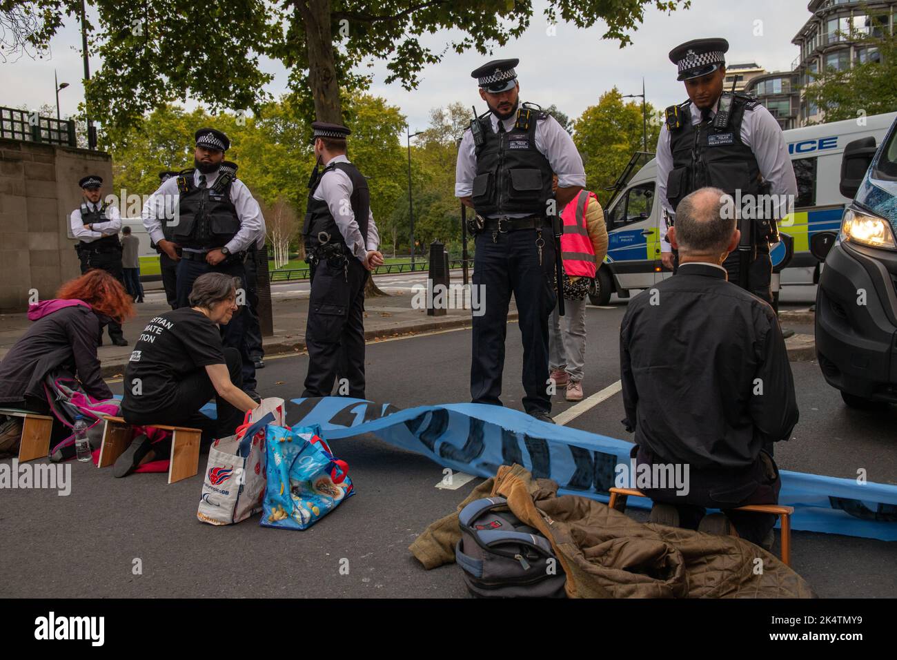 London, England, Großbritannien, 04/10/2022, Eine Koalition von Klimagruppen entgleist den Start des Energy Intelligence Forum (ehemals Oil and Money Forum) mit Straßen- und Türblöcken im Intercontinental Hotel, Park Lane. Die Koalition bestand aus XR Youth, Extinction Rebellion, Money Rebellion, Christian Climate Action, Fossil Free London und Debt for Climate Credit: Denise Laura Baker/Alamy Live News Stockfoto