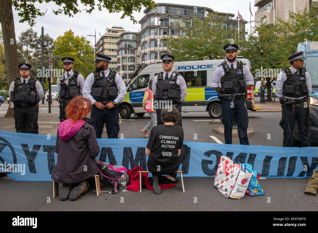London, England, Großbritannien, 04/10/2022, Eine Koalition von Klimagruppen entgleist den Start des Energy Intelligence Forum (ehemals Oil and Money Forum) mit Straßen- und Türblöcken im Intercontinental Hotel, Park Lane. Die Koalition bestand aus XR Youth, Extinction Rebellion, Money Rebellion, Christian Climate Action, Fossil Free London und Debt for Climate Credit: Denise Laura Baker/Alamy Live News Stockfoto