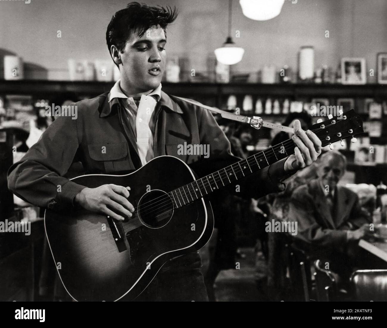 Elvis Presley spielt Gitarre in einem Restaurant. King Creole Publicity Still (Paramount, 1958). Stockfoto Elvis Presley spielt Gitarre in einem Restaurant. King Creole Publicity Still (Paramount, 1958). Stockfoto