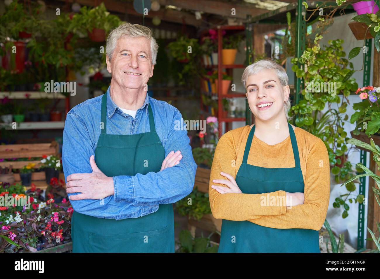 Ältere Gärtnerin als stolze Chefin und junge Frau in der Ausbildung zum