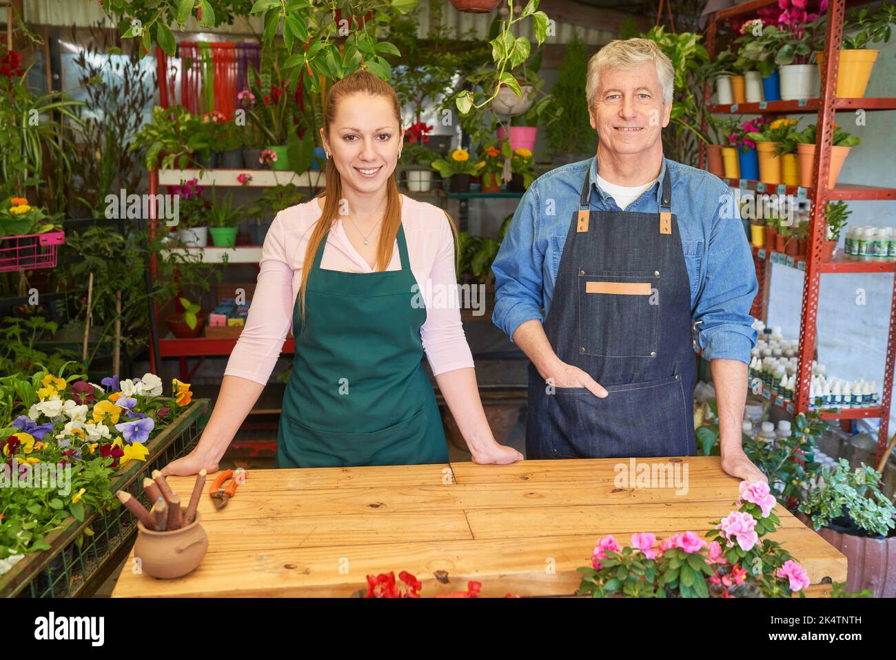 Älterer Gärtner als Besitzer und Florist in der Ausbildung als Team im