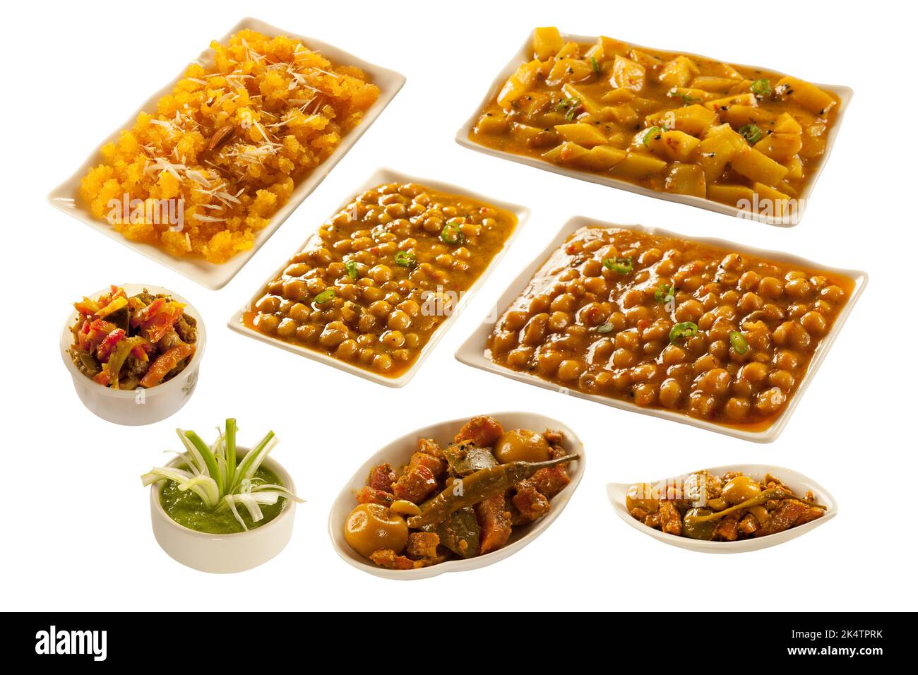 Auswahl an indischen pakistanischen Gerichten mit Kichererbsenfleisch und Kartoffeln mit süßem Grieß-Dessert und Gurken Stockfoto
