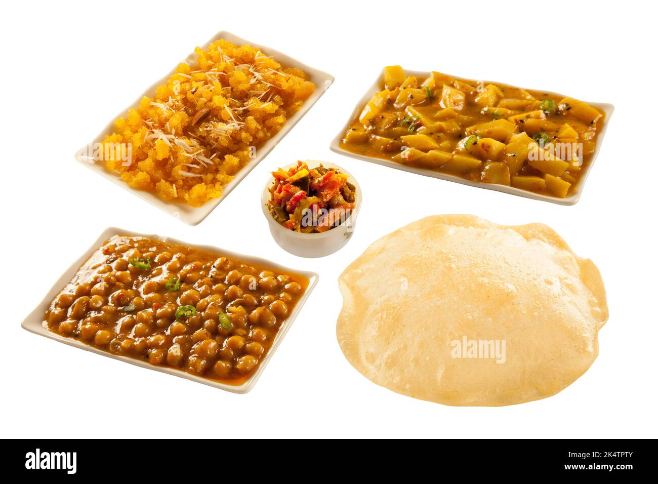 Puri Paratha mit Kichererbsen, Kartoffelpuffer, süßer Halwa und Gurkenscheiben Stockfoto