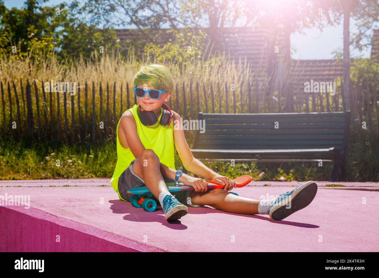 Junge mit grünen Haaren Pose halten Skate auf einer Rampe im Skatepark Stockfoto