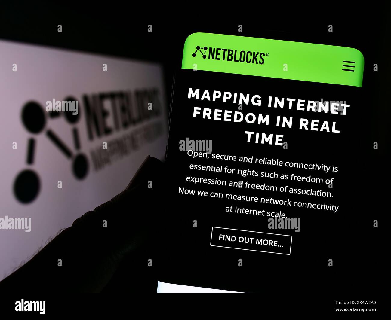 Person, die das Smartphone mit der Webseite des Internet Watchdog NetBlocks Ltd. Auf dem Bildschirm vor dem Logo hält. Konzentrieren Sie sich auf die Mitte des Telefondisplays. Stockfoto