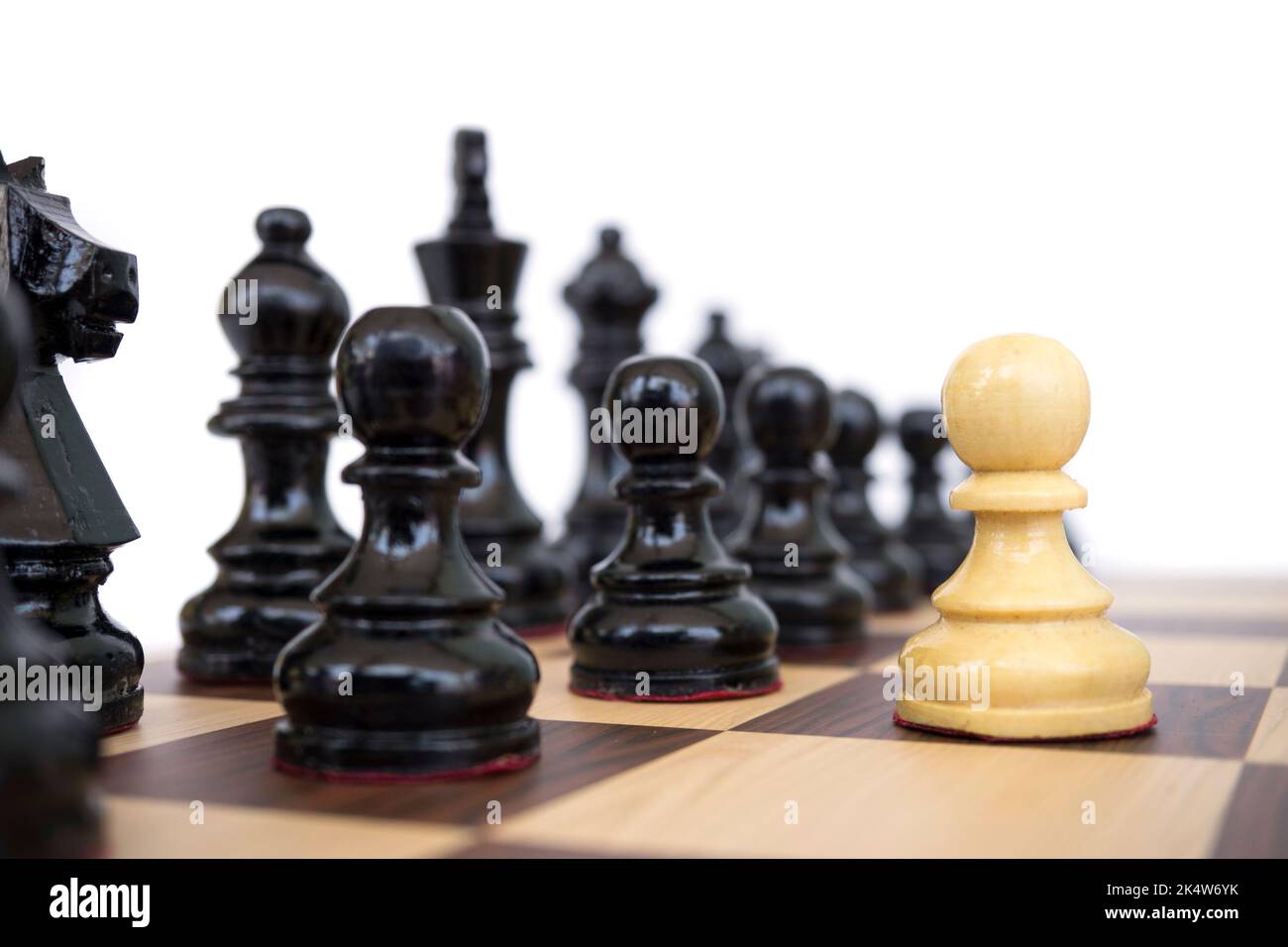 Das Konzept eines Soldaten, der allein vorrückt, um mit dem Feind zu verhandeln, zeigt, dass das weiße Schachspiel allein vor dem Feind steht. Stockfoto