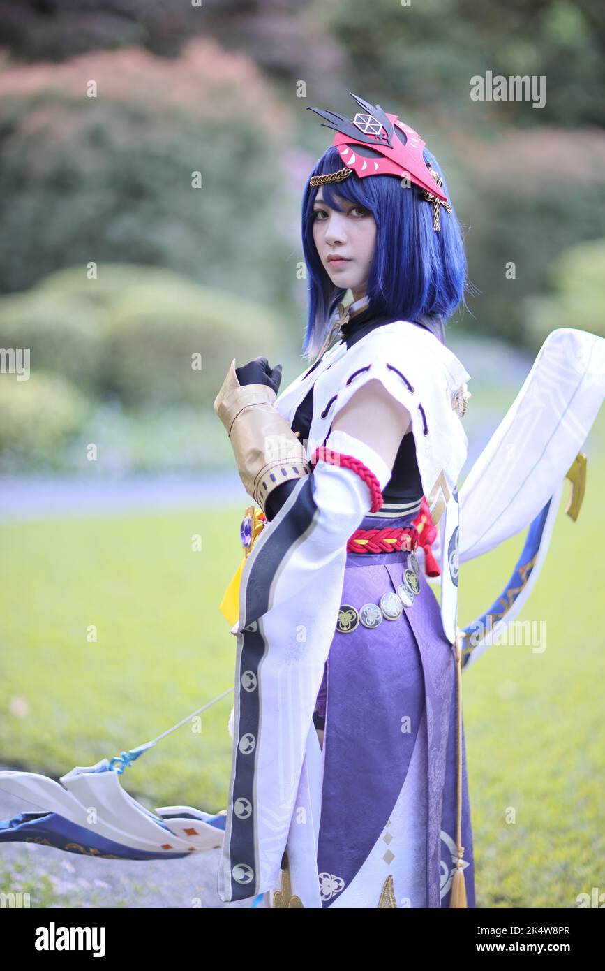 Japanische junge Frau Jäger Cosplay mit Bogen auf japanischen Garten Stockfoto