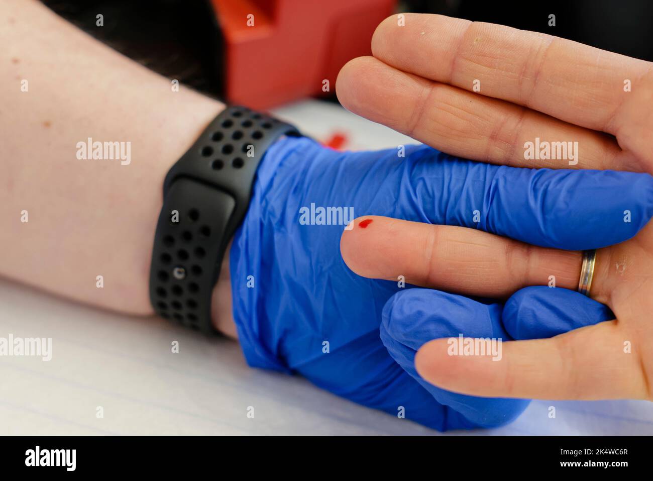 Kiel, Deutschland. 04. Oktober 2022. Ein Tropfen Blut fließt aus dem Finger eines Mannes. Am 4. Oktober 2022 veranstaltete der Nordost-Blutspendedienst des Deutschen Roten Kreuzes (DRK) im Landeshaus Kiel eine Blutspendekampagne. Zu diesem Zweck wurde der alte Plenarsaal in ein Blutspendezentrum umgewandelt. Blutspenden helfen, die medizinische Versorgung von Patienten zu sichern, die zum Beispiel im Zuge größerer Operationen oder zur begleitenden Chemotherapie nach Krebs dringend Präparate aus Spenderblut benötigen. Quelle: Frank Molter/dpa/Alamy Live News Stockfoto