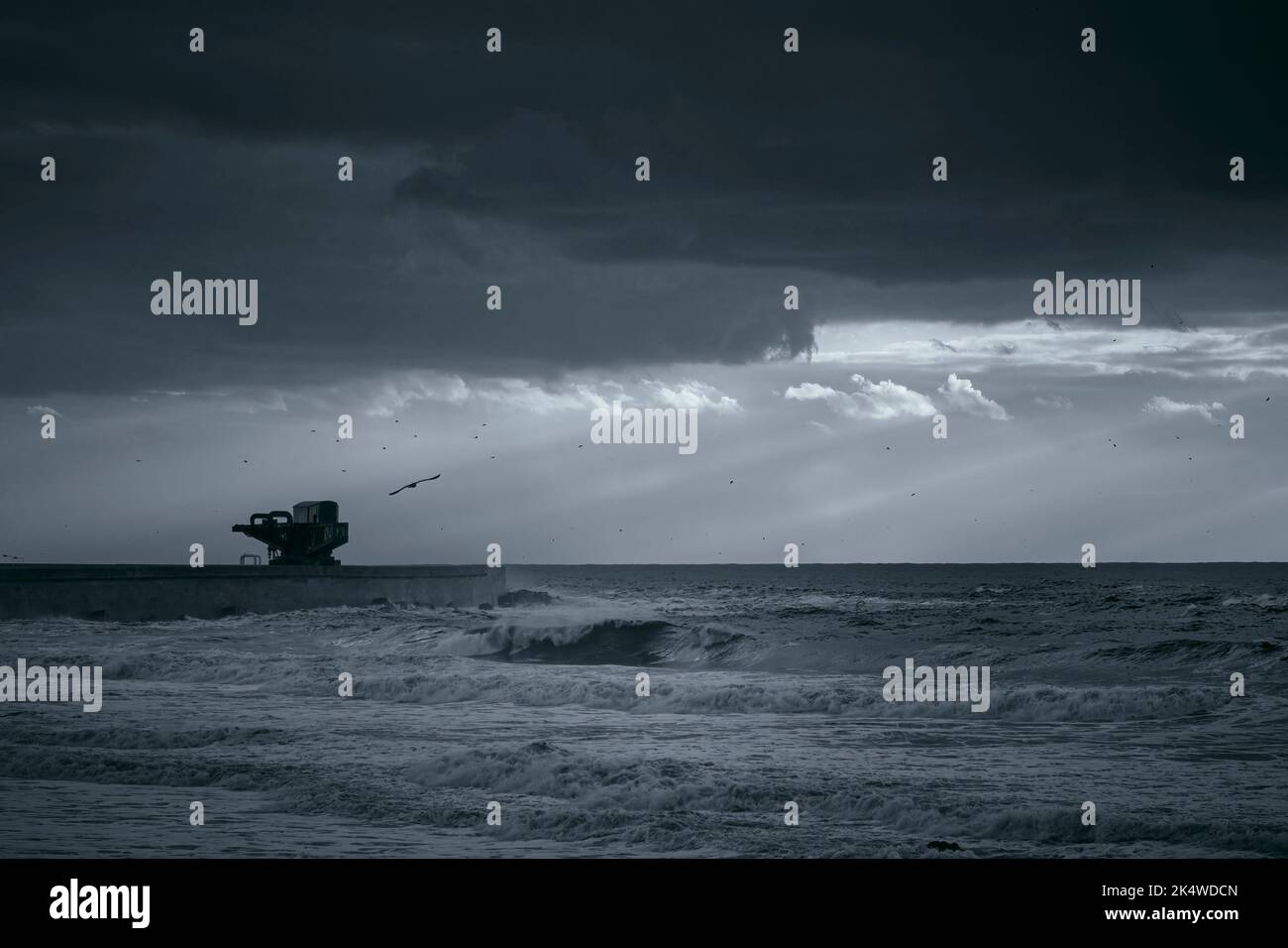 Dramatische Meereslandschaft mit Sonnenstrahlen. Leixoes Hafen Nordwand, nördlich von Portugal. Infrarotfilter verwendet. Getöntes Bkue. Stockfoto