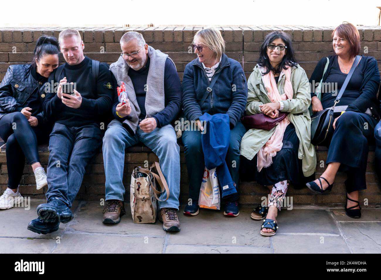 Die Briten ruhen sich aus, während sie sich in der Westminster Hall, London, Großbritannien, die Königin im Staat liegen sehen. Stockfoto