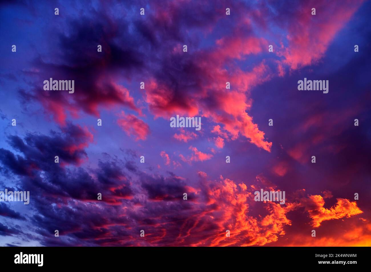 Erstaunlicher farbenprächtiger Sonnenuntergang- oder Sonnenaufgangshimmel mit orangefarbenem Pink-Lila und blauem Dramatik Stockfoto