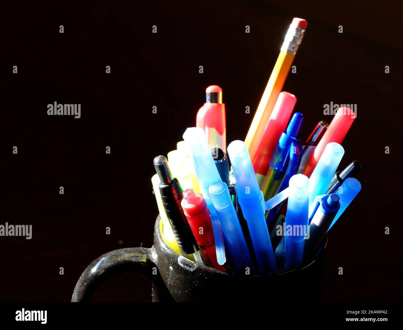 Mehrere Stifte und Stifte in einem Becher auf dem Schreibtisch für Arbeit oder Bildung Stockfoto