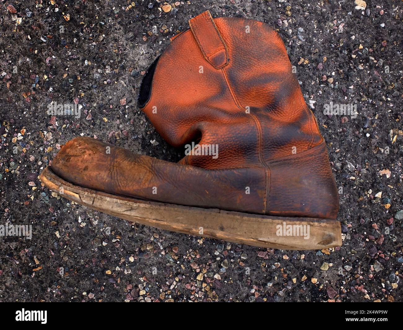 Detail der alten verwitterten abgenutzten Lederstiefel auf der Straße aufgegeben Stockfoto