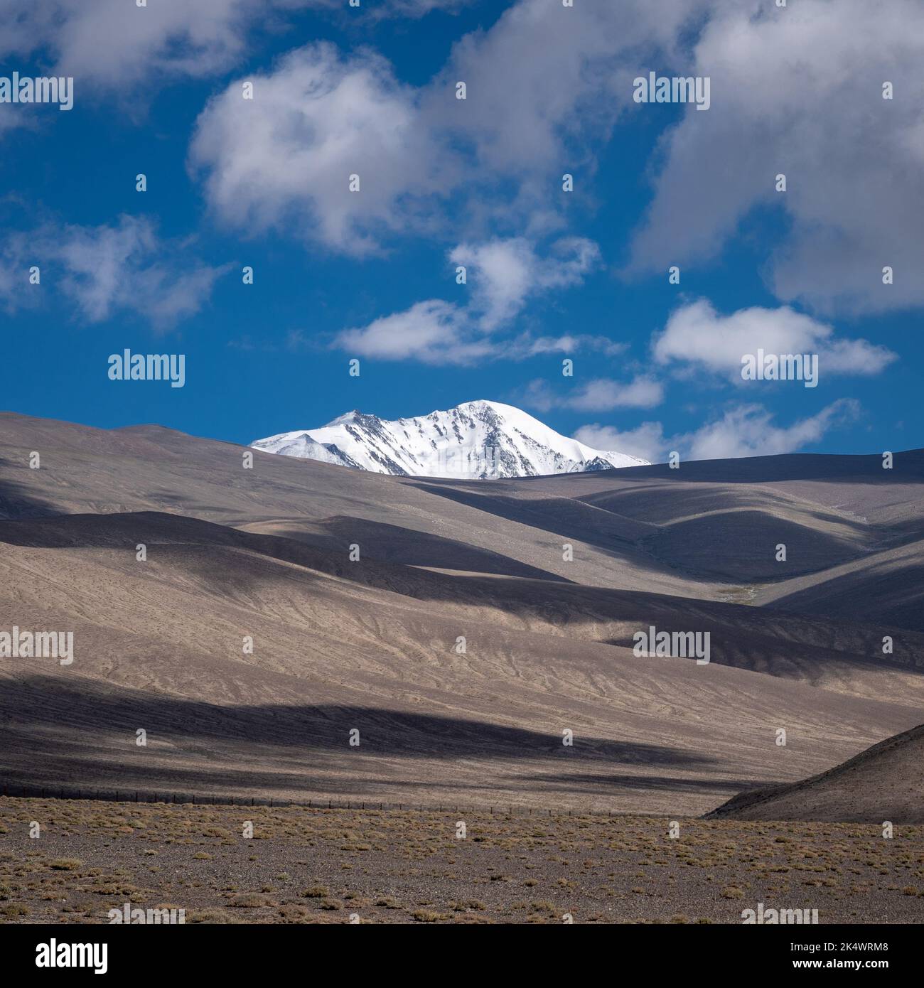 Wüstenlandschaft mit schneebedeckten Bergen rund um den Karakul-See, den Murghab-Bezirk, Gorno-Badakshan, in der Pamir-Region Tadschikistans Stockfoto