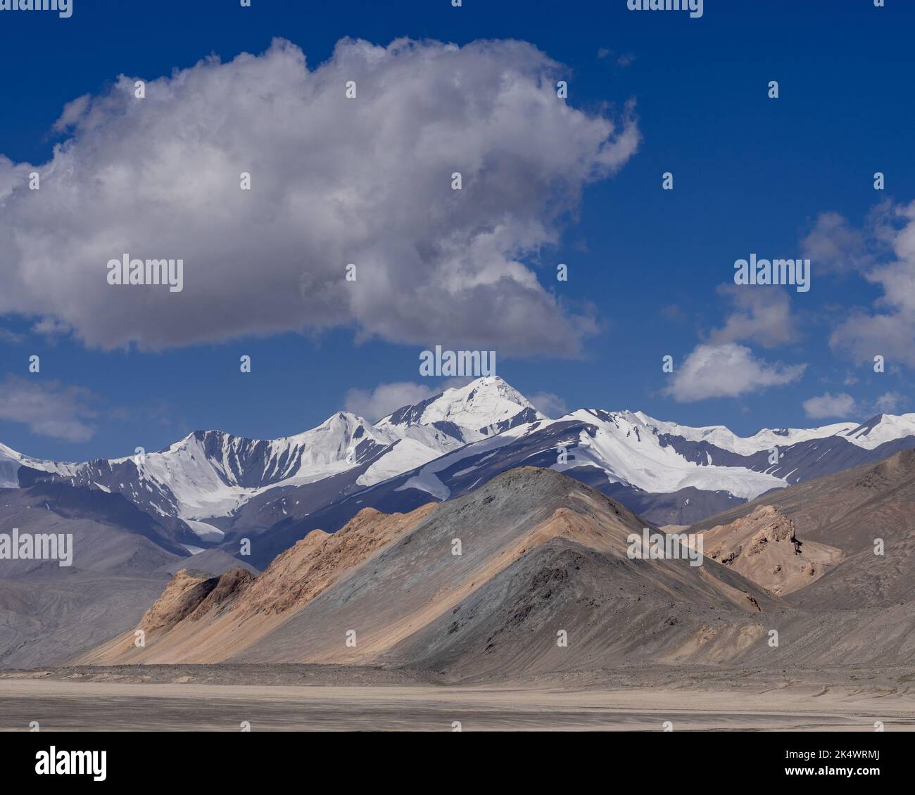 Bunte Hochwüstenlandschaft mit schneebedeckten Bergen entlang des Pamir Highway zwischen Karakul und Kyzyl Art, Murghab, Gorno-Badakshan, Tadschikistan Stockfoto