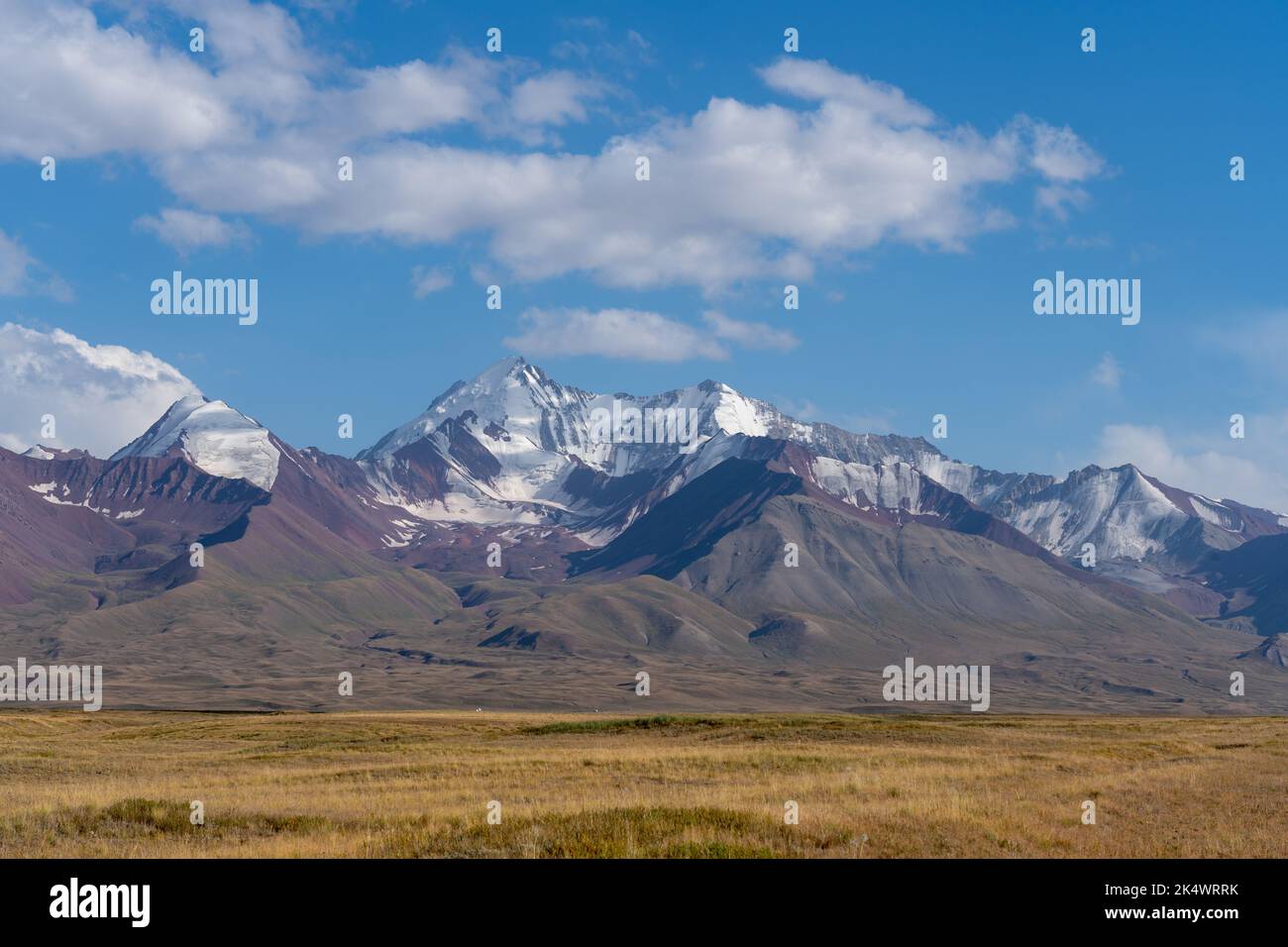 Blick auf die schneebedeckten Trans-Alai- oder Trans-Alay-Berge im Sary-Tash-Tal, Kirgisistan mit Weide im Vordergrund entlang des Pamir-Highways Stockfoto