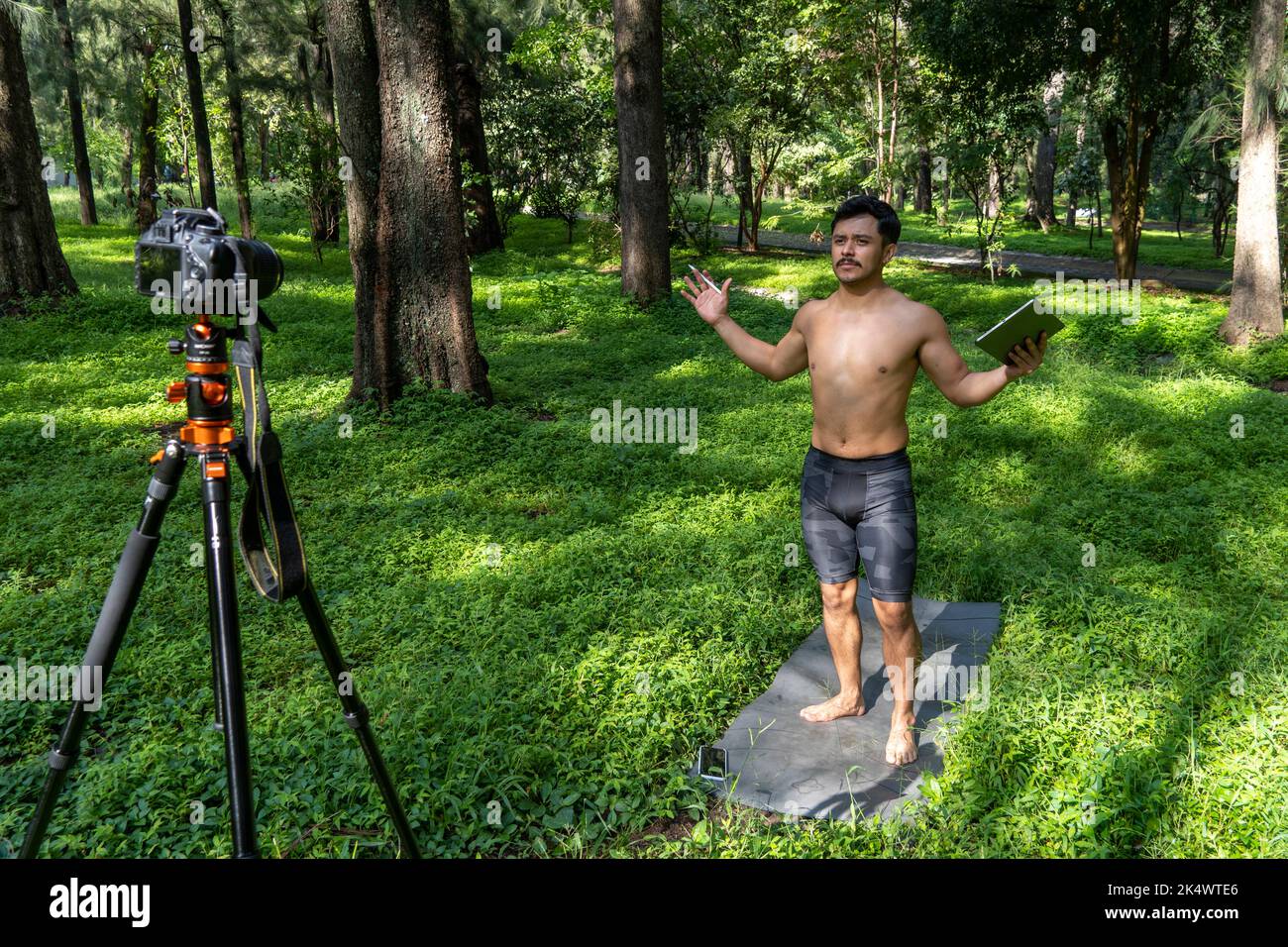 Kerl mit Tablet macht Video-Blog auf dem Telefon. Isolierte Person, die Online-Kurse gibt. Mann, der Online-Kurse mit dem Telefon gibt. Stockfoto