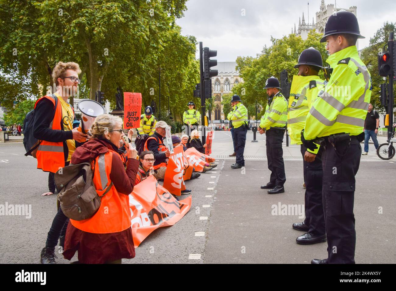 London, England, Großbritannien. 4. Oktober 2022. Polizeimonitor Stoppt einfach die Öldemonstranten, die die Straßen auf dem Parliament Square blockieren. Einige Aktivisten klebten ihre Hände an die Straße, und der Protest war Teil einer Reihe von Demonstrationen, die täglich in Westminster stattfanden, wobei die Klimaschutzgruppe ein Ende der fossilen Brennstoffe und einen Wechsel zu erneuerbaren Energien forderte. (Bild: © Vuk Valcic/ZUMA Press Wire) Stockfoto