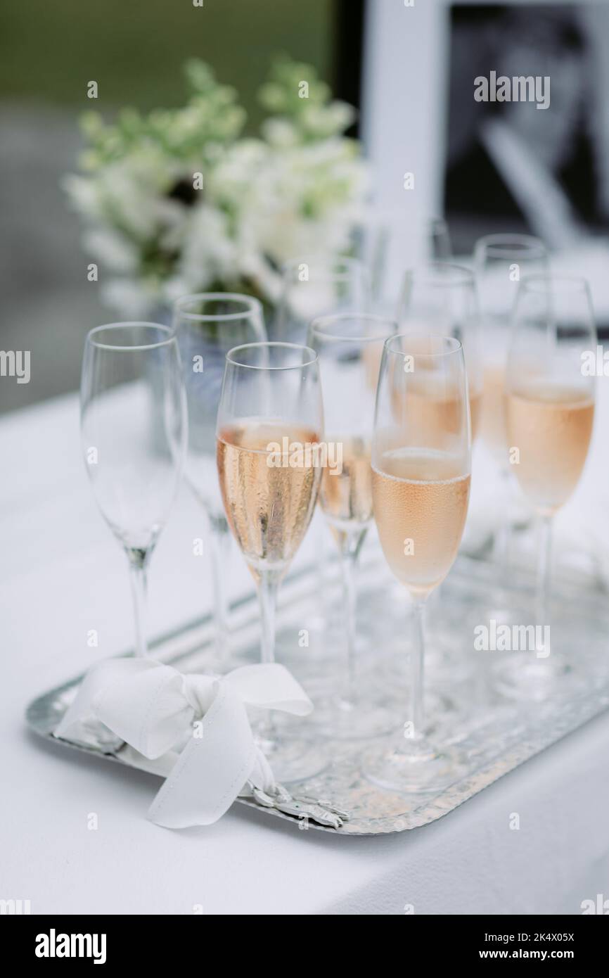 Rosafarbener Champagner in Flöten auf einem silbernen Tablett bei einer Hochzeit Stockfoto
