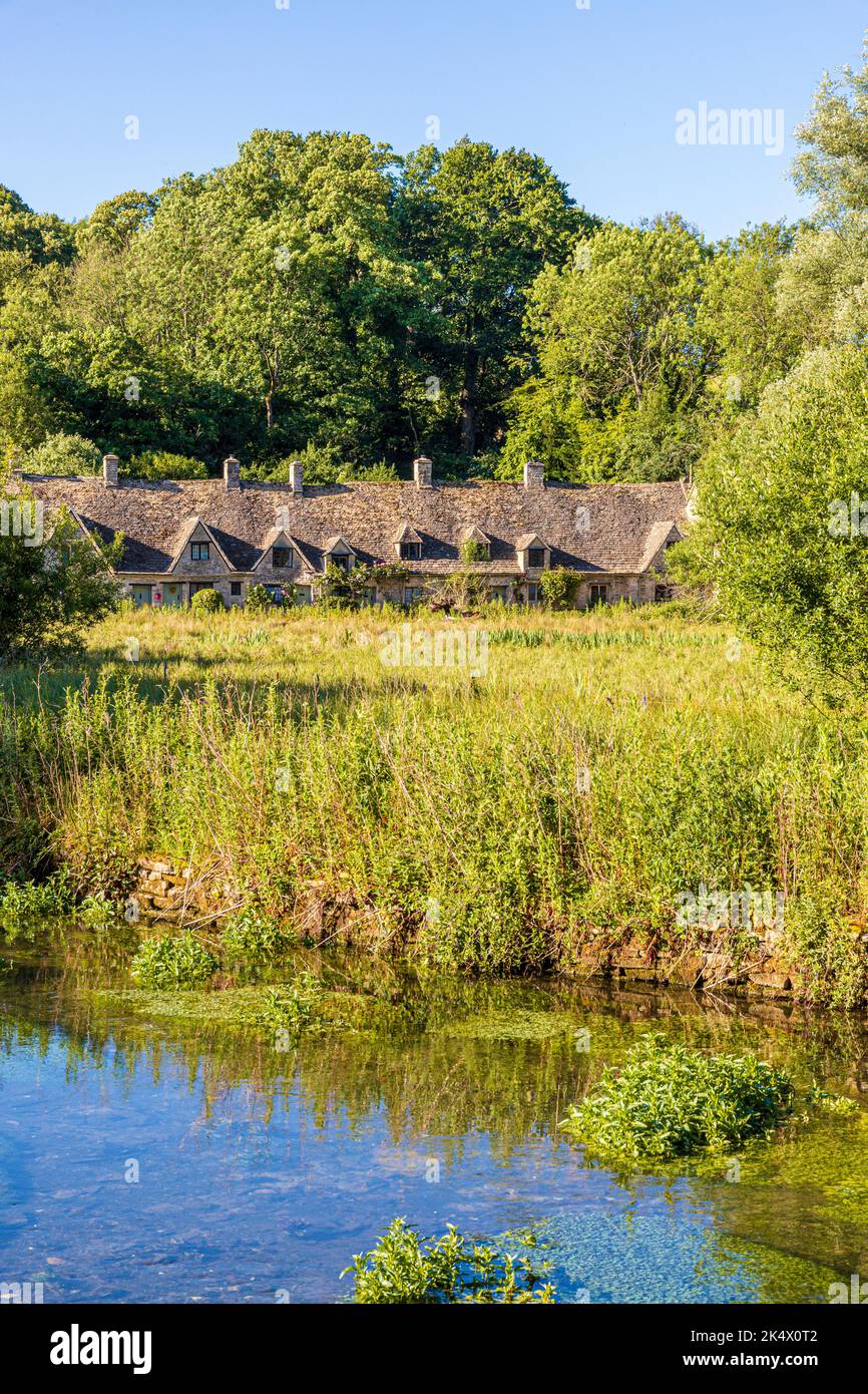 Im Hochsommerlicht am frühen Morgen in der Arlington Row am Fluss Coln im Cotswold-Dorf Bibury, Gloucestershire, England Stockfoto