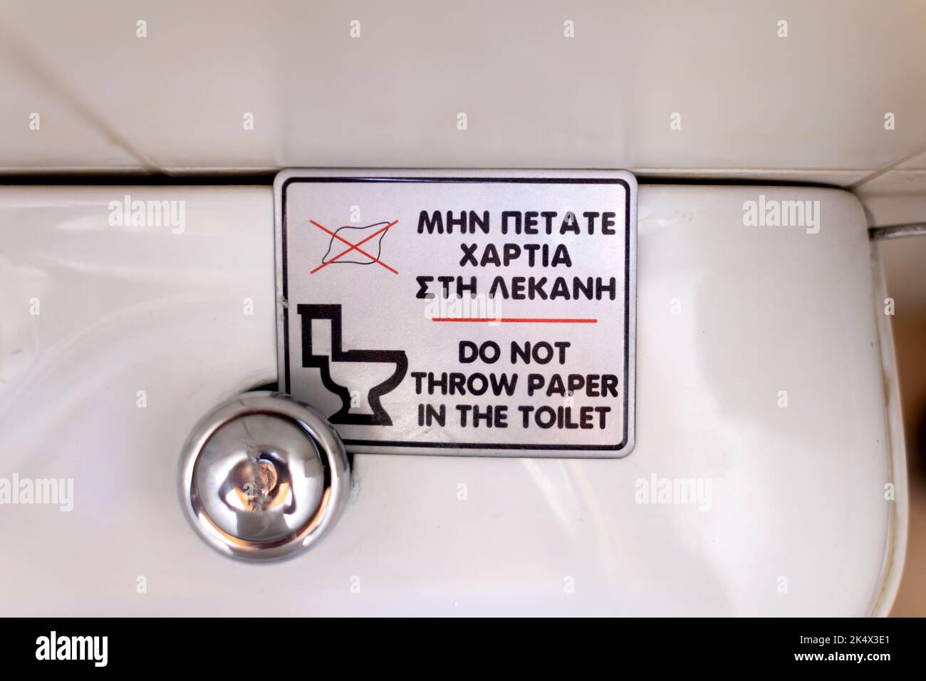 Ein Schild auf einer griechischen Toilettenzisterne, auf dem Leute, die die Toilette benutzen, aufgefordert werden, kein Toilettenpapier in die Toilette zu legen. Gespültes Papier kann Rohre blockieren Stockfoto