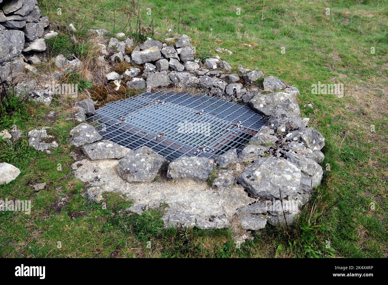 Ein schützender Grill blockiert den Eingang zu einem alten Schacht bei der Magpie Mine in Derbyshire. Die Mine förderte einst Bleierz, Galena. Stockfoto