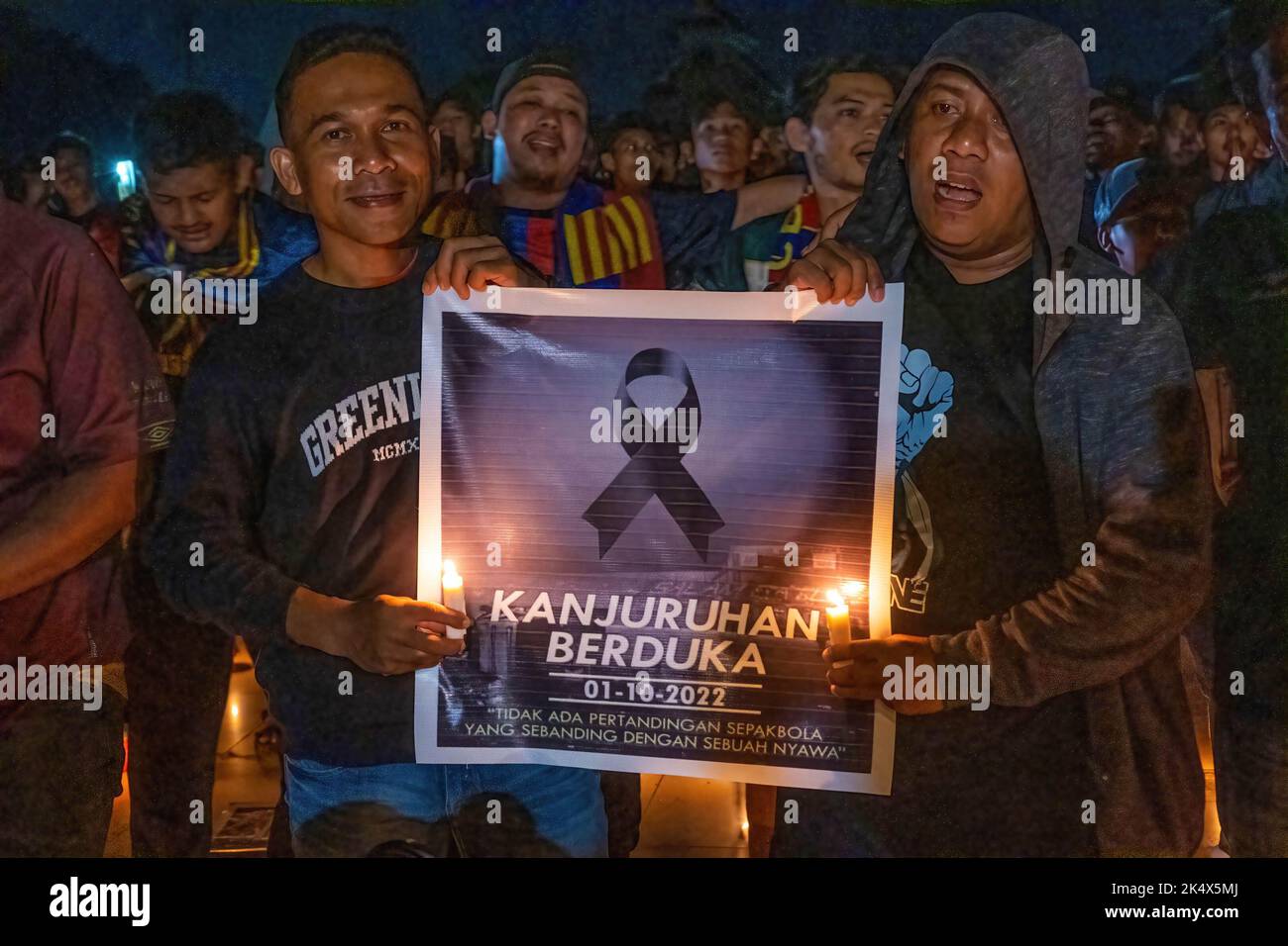 Fußballfans halten ein Banner mit einem schwarzen Band in Ehren der Opfer der Tragödie im Kanjuruhan-Stadion. Die Kendari City Football Supporting Community hielt ein Gebet für die Anhänger des Malang Arema Clubs ab, die bei der Tragödie im Kanjuruhan Stadium, Malang, ums Leben kamen. Stockfoto