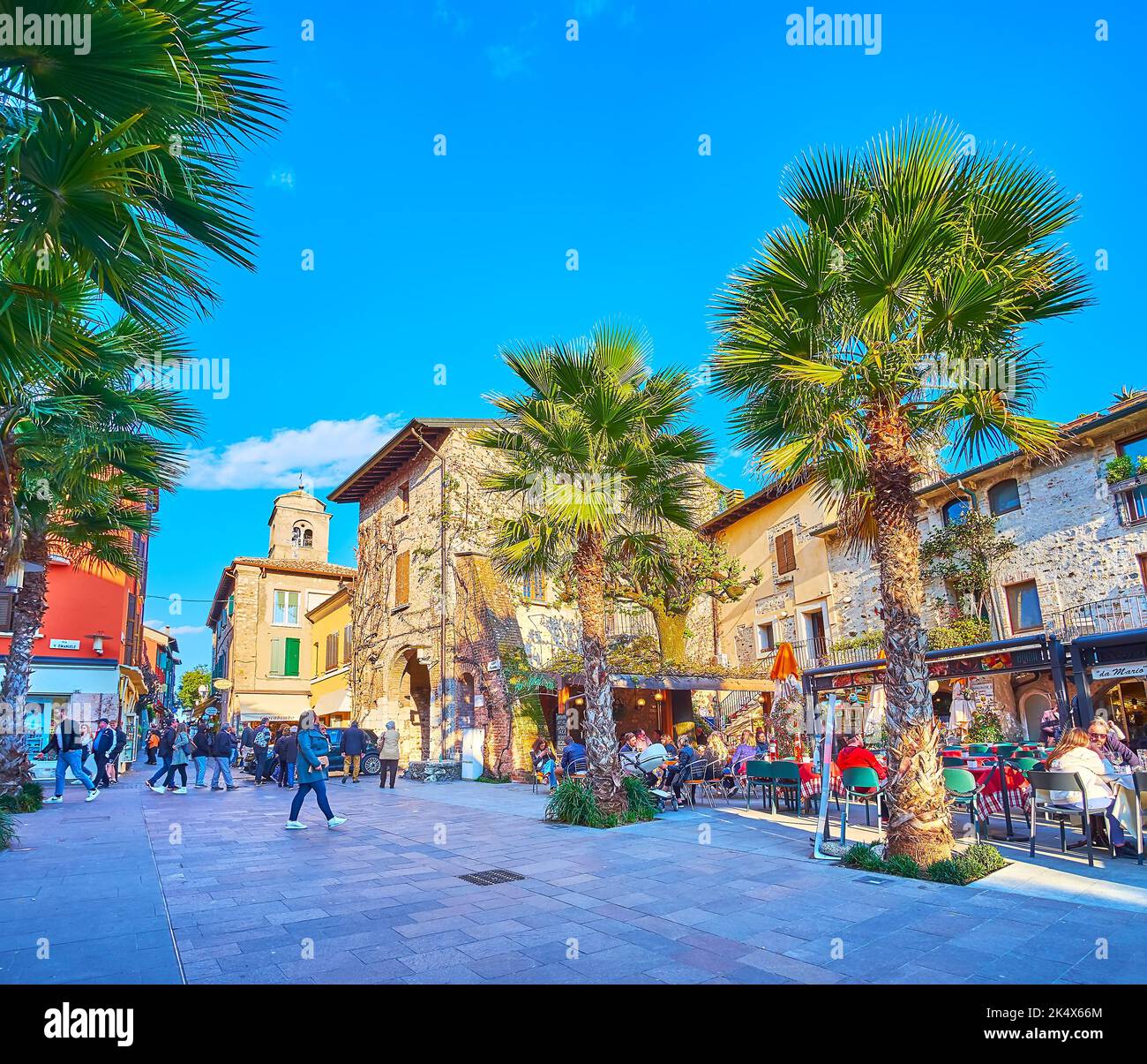 Die Reihe kleiner Restaurants unter den hohen Palmen, Piazza Flaminia, Sirmione, Italien Stockfoto