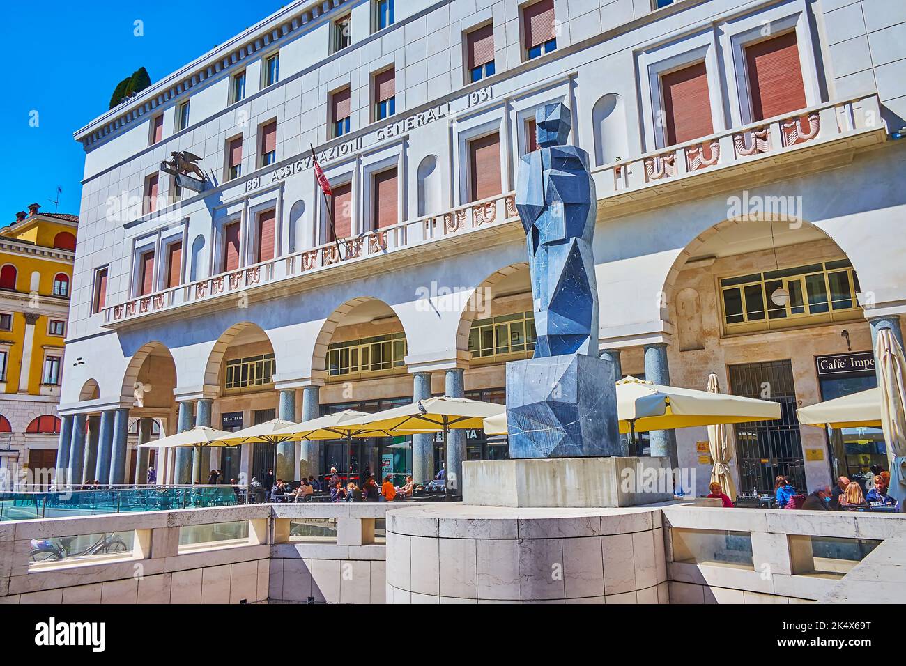 BRESCIA, ITALIEN - 10. APRIL 2022: Die moderne Steinstatue in Fontana del Bigio gegen den Palazzo Assicurazioni Generali und Outdoo Stockfoto