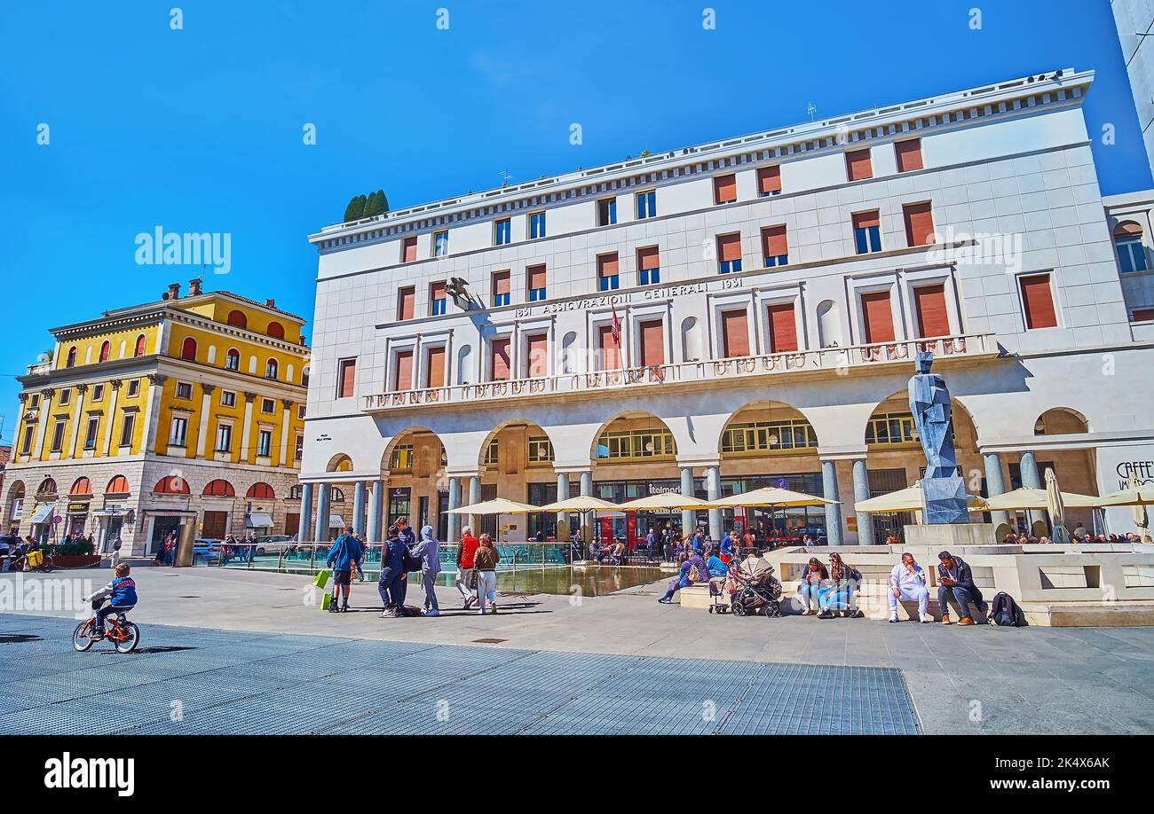 BRESCIA, ITALIEN - 10. APRIL 2022: Die überfüllte Piazza della Vittoria mit moderner Statue in Fontana del Bigio und Palazzo Assicurazioni Stockfoto