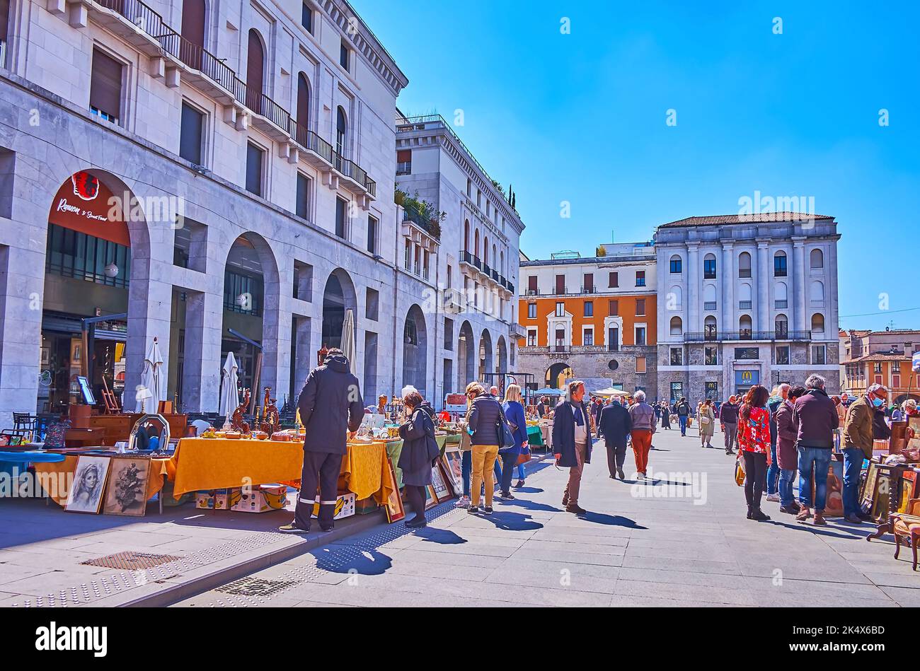 BRESCIA, ITALIEN - 10. APRIL 2022: Die Gasse des Flohmarktes, die sich inmitten der Piazza della Vittoria (Siegesplatz) mit Postpalast befindet, am 10. April Stockfoto