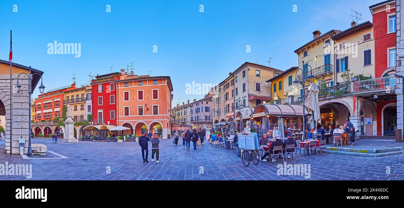 DESENZANO DEL GARDA, ITALIEN - 10. APRIL 2022: Panorama der Dämmerung Piazza Giuseppe Malvezzi mit gemütlichen Restaurants und Bars im Freien, am 10. April in Stockfoto