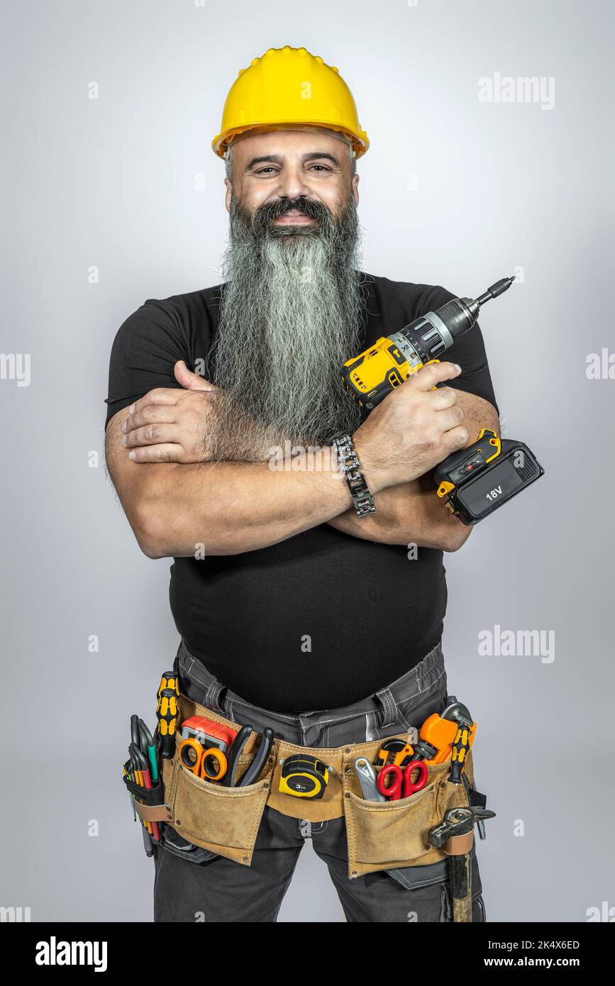 Lächelnder Arbeiter mit gekreuzten Armen und langem Bart. Stockfoto
